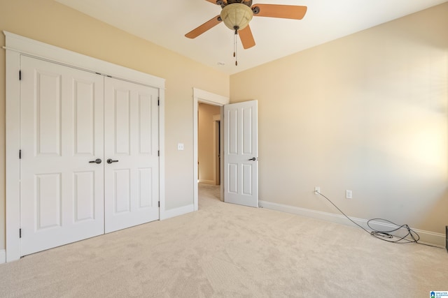 unfurnished bedroom with ceiling fan, light colored carpet, and a closet