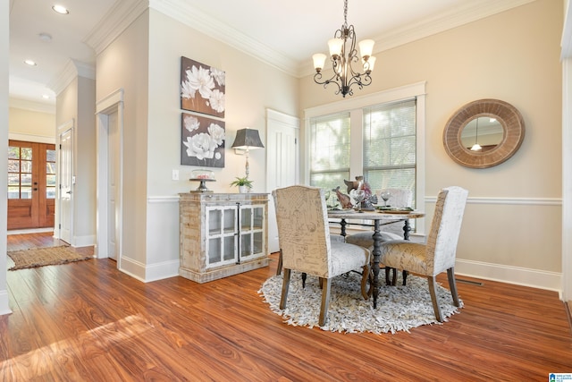 dining area with wood-type flooring, an inviting chandelier, and a wealth of natural light