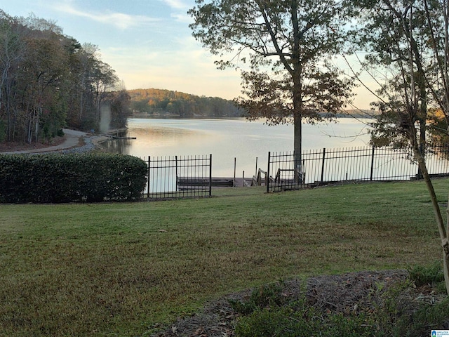 yard at dusk featuring a water view