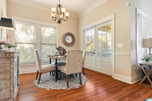 dining area featuring hardwood / wood-style floors, ornamental molding, and a notable chandelier