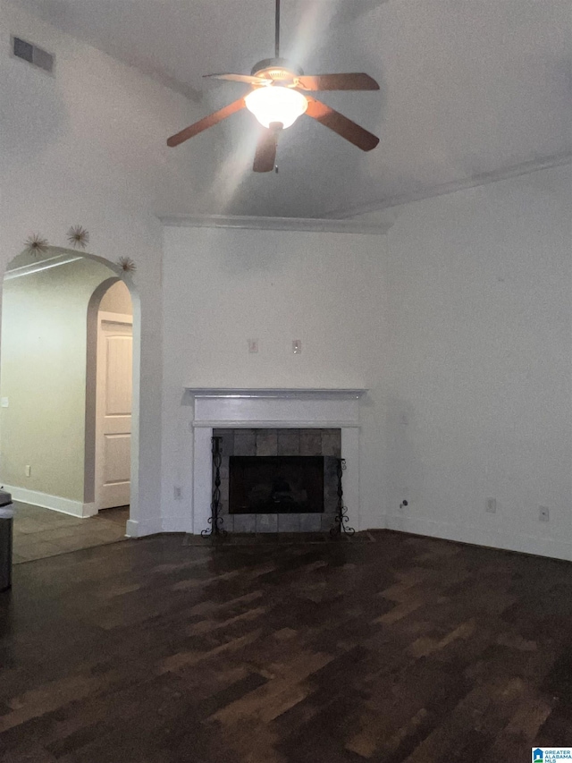 unfurnished living room with ceiling fan, dark hardwood / wood-style flooring, a tile fireplace, and vaulted ceiling