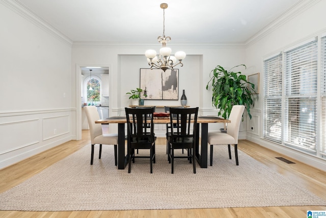 dining room featuring crown molding, an inviting chandelier, and hardwood / wood-style flooring