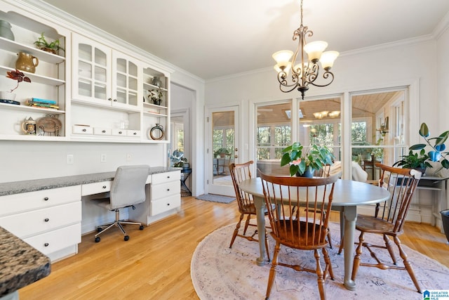 dining space featuring a notable chandelier, light hardwood / wood-style floors, and crown molding