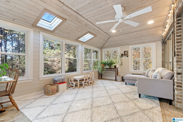 sunroom featuring lofted ceiling with skylight, ceiling fan, and wood ceiling