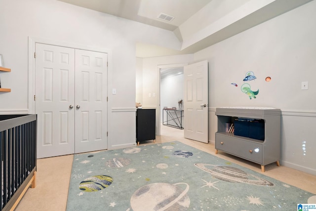 bedroom featuring light carpet and a closet