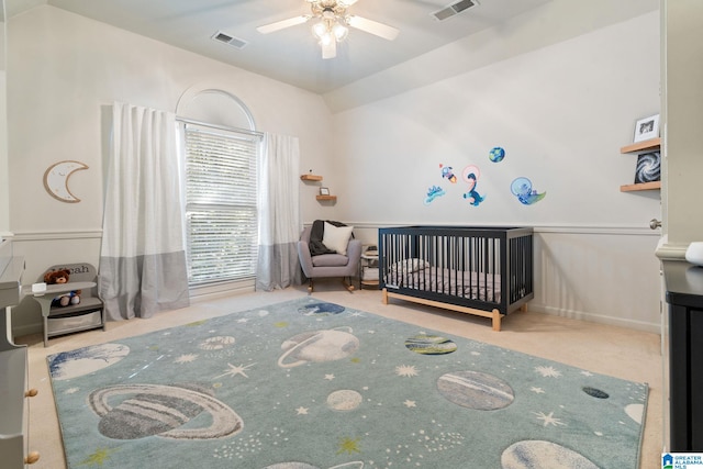 bedroom featuring ceiling fan, carpet, and a nursery area