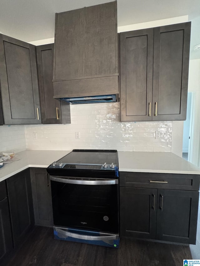 kitchen with stainless steel range with electric stovetop, dark wood-type flooring, dark brown cabinetry, and tasteful backsplash