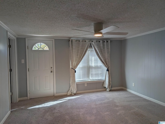 foyer with a textured ceiling, light colored carpet, ceiling fan, and crown molding