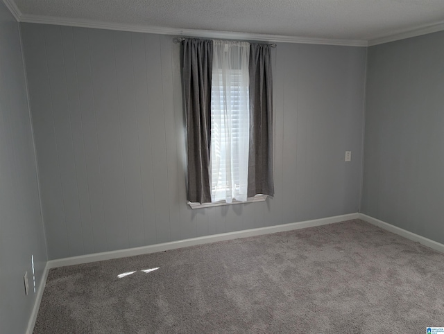 unfurnished room featuring a textured ceiling, carpet floors, and ornamental molding