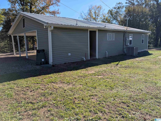 rear view of house with a lawn and central air condition unit