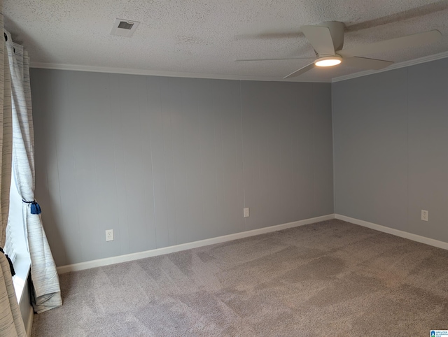 empty room featuring ceiling fan, crown molding, carpet floors, and a textured ceiling