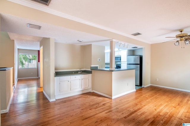 kitchen with ceiling fan, sink, kitchen peninsula, appliances with stainless steel finishes, and light wood-type flooring