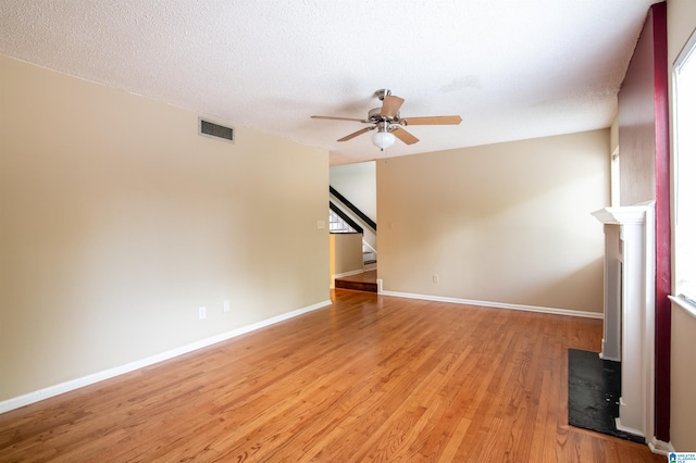 unfurnished living room with ceiling fan, light hardwood / wood-style flooring, and a textured ceiling