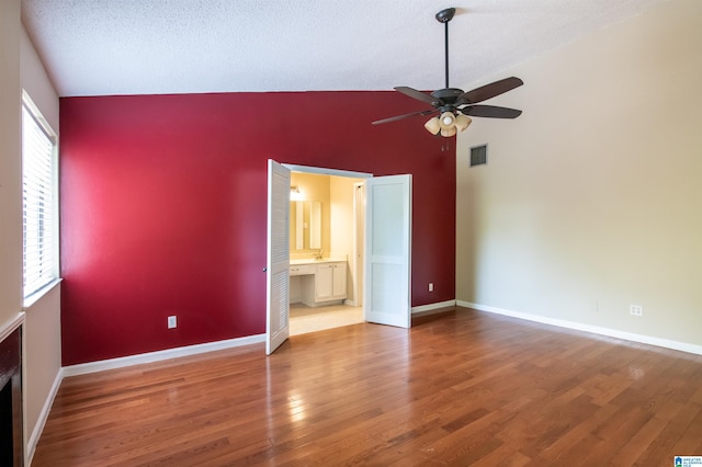 unfurnished bedroom with multiple windows, ceiling fan, hardwood / wood-style floors, and high vaulted ceiling