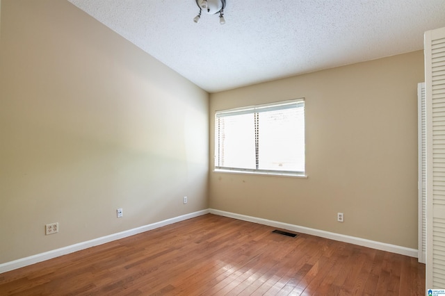 unfurnished bedroom with hardwood / wood-style floors and a textured ceiling