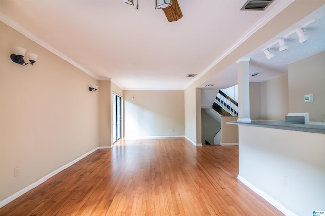 unfurnished living room with track lighting, crown molding, and light hardwood / wood-style flooring