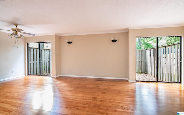 empty room with a textured ceiling, light hardwood / wood-style floors, ceiling fan, and ornamental molding