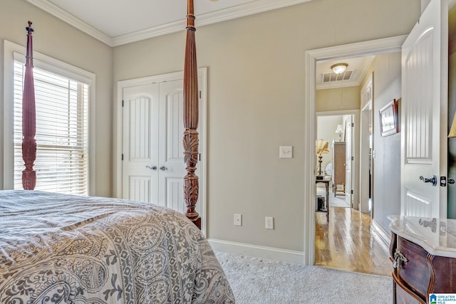 bedroom with ornamental molding, light hardwood / wood-style flooring, and a closet