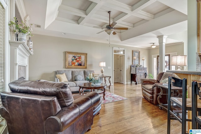 living room with ceiling fan, coffered ceiling, decorative columns, crown molding, and light hardwood / wood-style floors