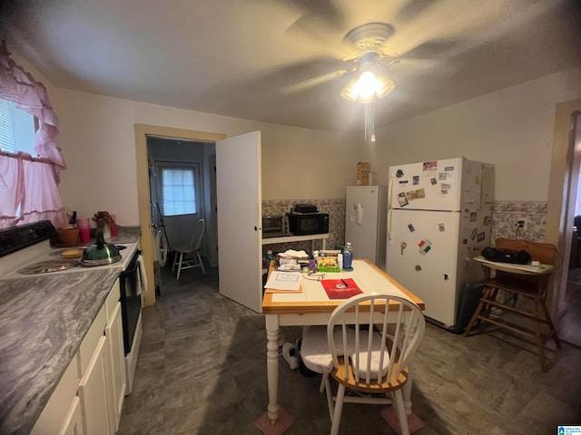 kitchen with ceiling fan, white cabinets, and white appliances