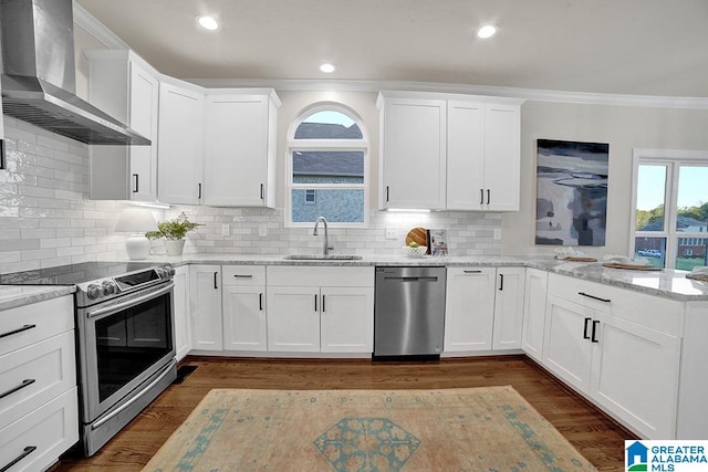 kitchen with white cabinets, sink, wall chimney exhaust hood, light stone counters, and stainless steel appliances