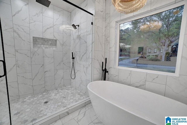 bathroom featuring independent shower and bath and an inviting chandelier