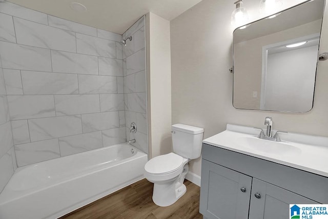 full bathroom featuring hardwood / wood-style floors, vanity, toilet, and tiled shower / bath