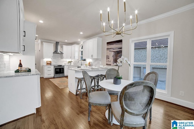 dining room with ornamental molding, a notable chandelier, dark wood-type flooring, and sink