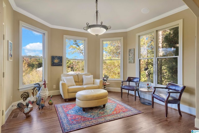 sitting room with hardwood / wood-style floors and crown molding