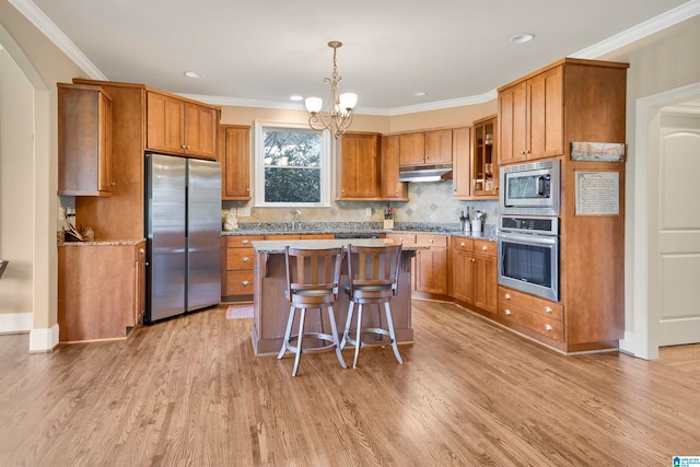 kitchen featuring crown molding, a center island, light wood-type flooring, and appliances with stainless steel finishes