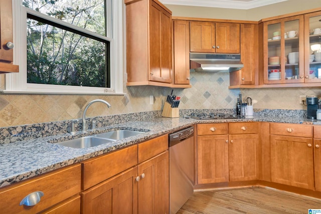 kitchen with sink, light stone countertops, ornamental molding, appliances with stainless steel finishes, and light hardwood / wood-style floors