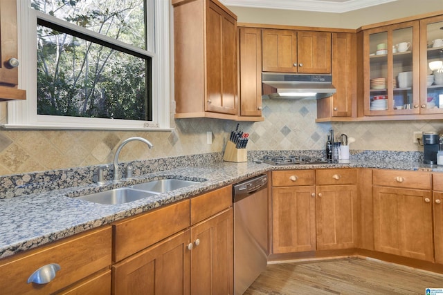 2399 Huntington Glen Dr, Homewood, AL 35226 - kitchen with under cabinet range hood, appliances with stainless steel finishes, light stone counters, brown cabinetry, and ornamental molding