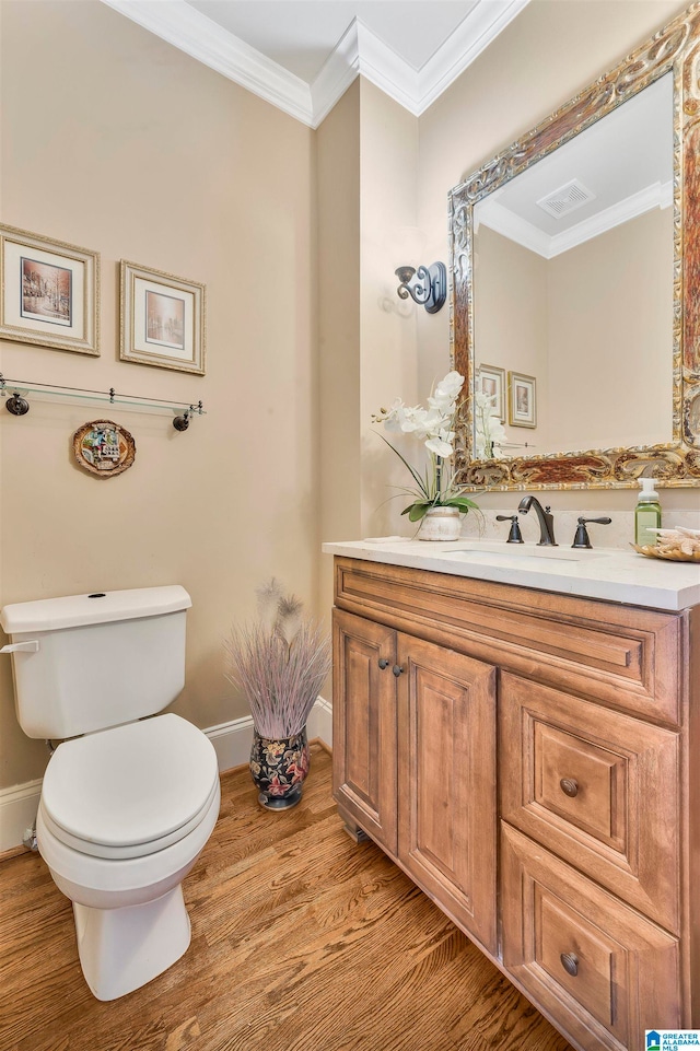 bathroom with vanity, toilet, wood-type flooring, and crown molding