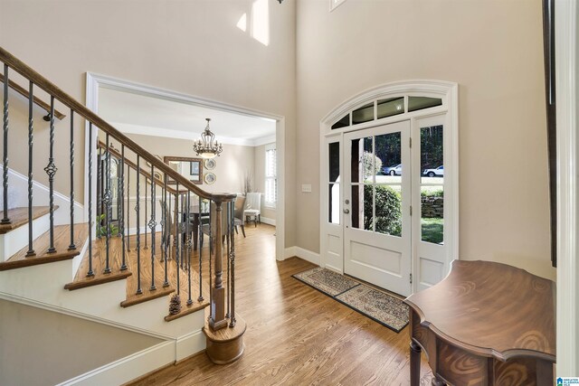 2399 Huntington Glen Dr, Homewood, AL 35226 - foyer entrance with a chandelier, wood finished floors, stairway, baseboards, and a high ceiling