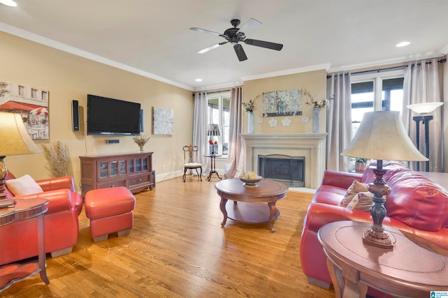 living room featuring crown molding, plenty of natural light, ceiling fan, and hardwood / wood-style flooring