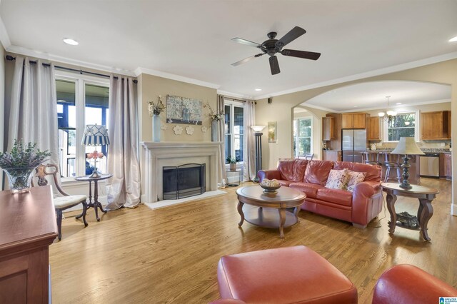 2399 Huntington Glen Dr, Homewood, AL 35226 - living room with arched walkways, a ceiling fan, ornamental molding, light wood-type flooring, and a glass covered fireplace