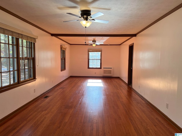 empty room featuring ceiling fan, ornamental molding, a textured ceiling, dark hardwood / wood-style flooring, and heating unit