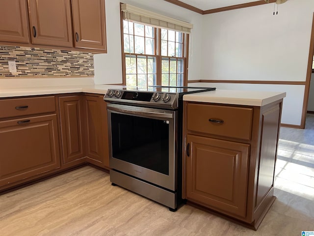 kitchen with kitchen peninsula, light wood-type flooring, backsplash, crown molding, and electric range