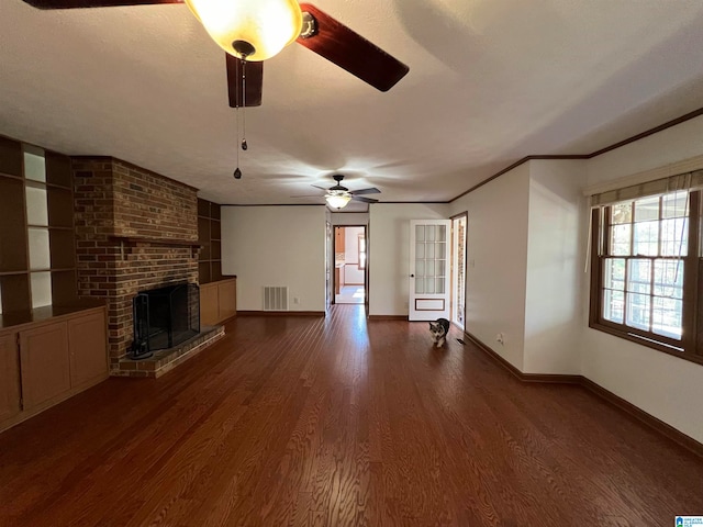 unfurnished living room with a textured ceiling, ceiling fan, dark hardwood / wood-style flooring, and a fireplace