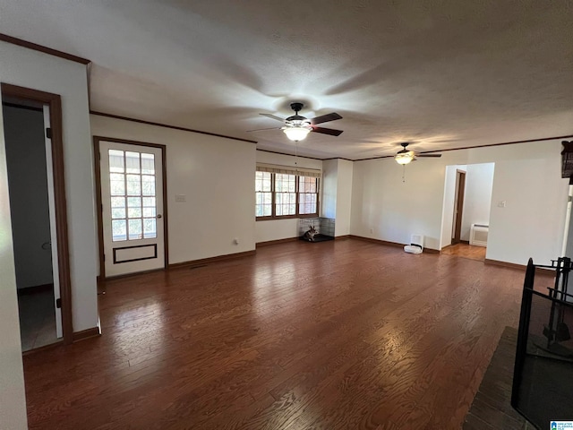 unfurnished living room featuring ceiling fan, dark hardwood / wood-style flooring, a healthy amount of sunlight, and a textured ceiling