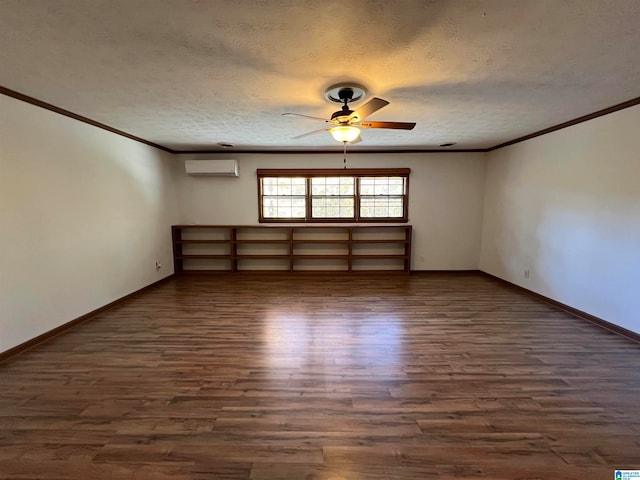 spare room featuring ceiling fan, dark wood-type flooring, a wall unit AC, a textured ceiling, and ornamental molding