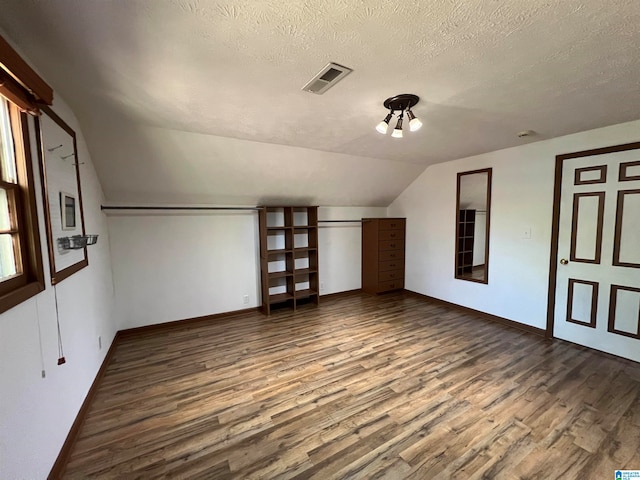 bonus room featuring wood-type flooring, a textured ceiling, and lofted ceiling