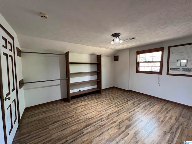 unfurnished bedroom with a textured ceiling, dark hardwood / wood-style floors, and ceiling fan