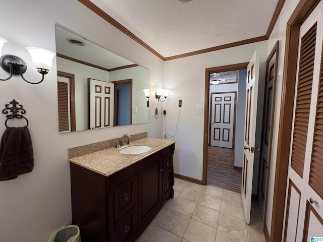 bathroom with tile patterned floors, vanity, ornamental molding, and a textured ceiling