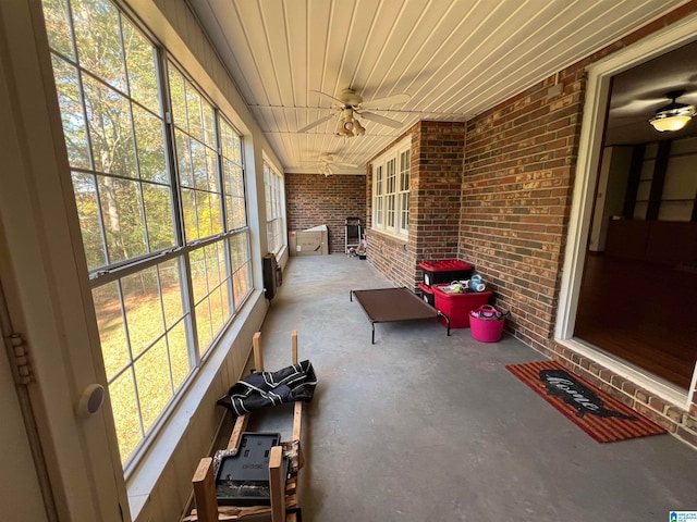 unfurnished sunroom with a wealth of natural light, wooden ceiling, and ceiling fan