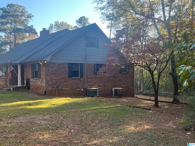 view of side of home featuring a lawn and central air condition unit