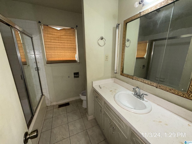 full bathroom with tile patterned floors, vanity, combined bath / shower with glass door, and toilet