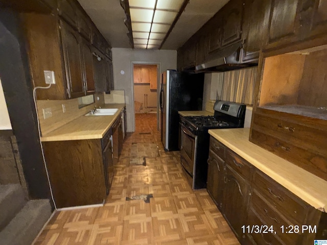 kitchen featuring sink, light parquet floors, dark brown cabinetry, and black range with gas cooktop