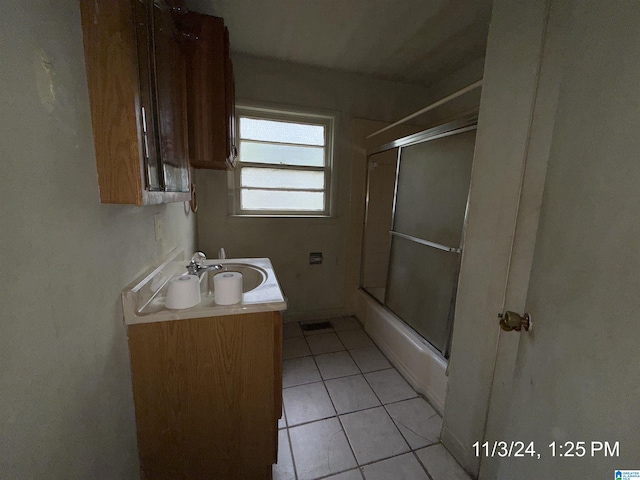 bathroom with combined bath / shower with glass door, vanity, and tile patterned flooring