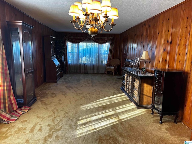 interior space with carpet, a notable chandelier, and wood walls